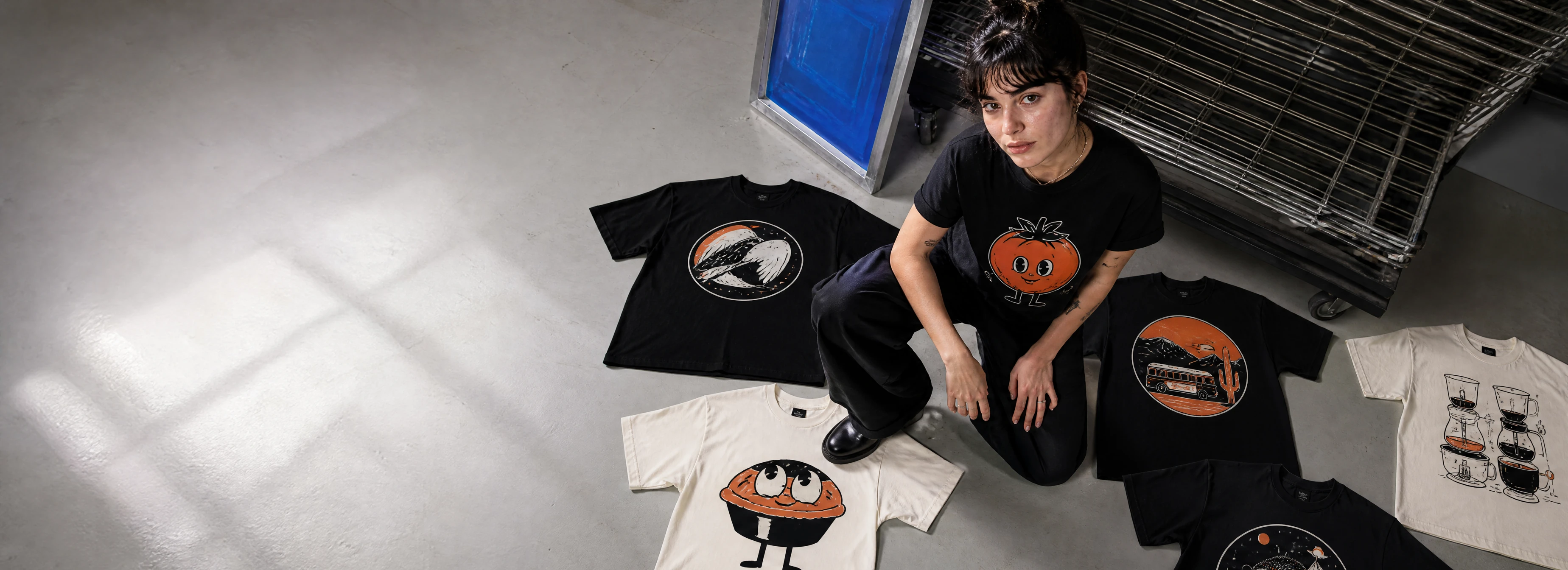A designer reviewing several original graphic T-shirts